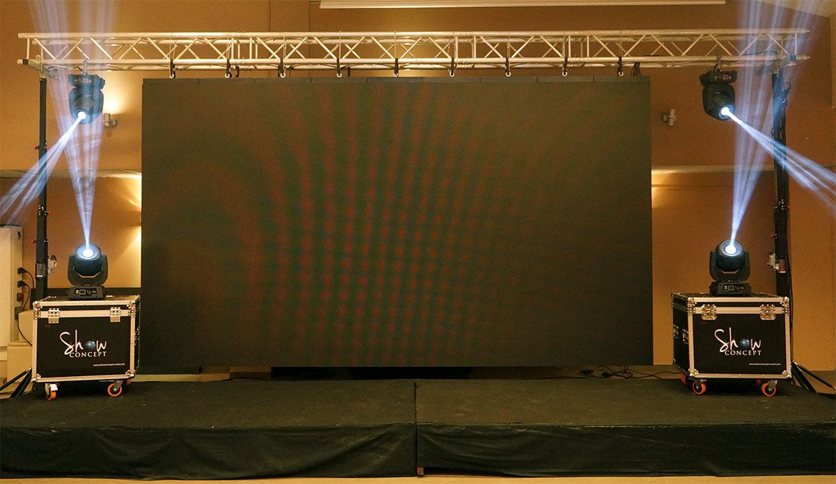 Écran LED sur scène, lyres posées sur flight cases